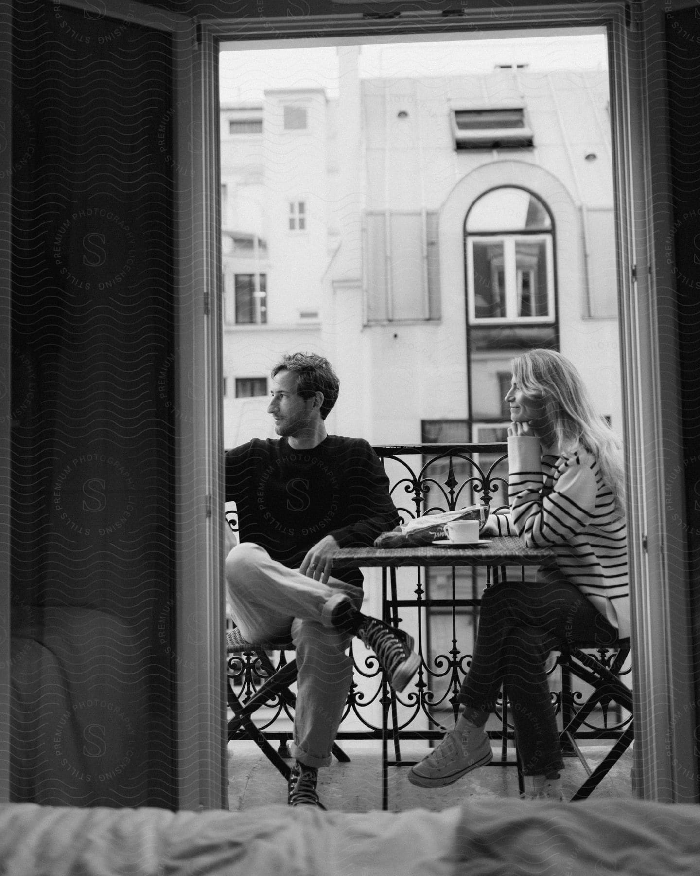 A man and a woman seated and having a conversation over a coffee