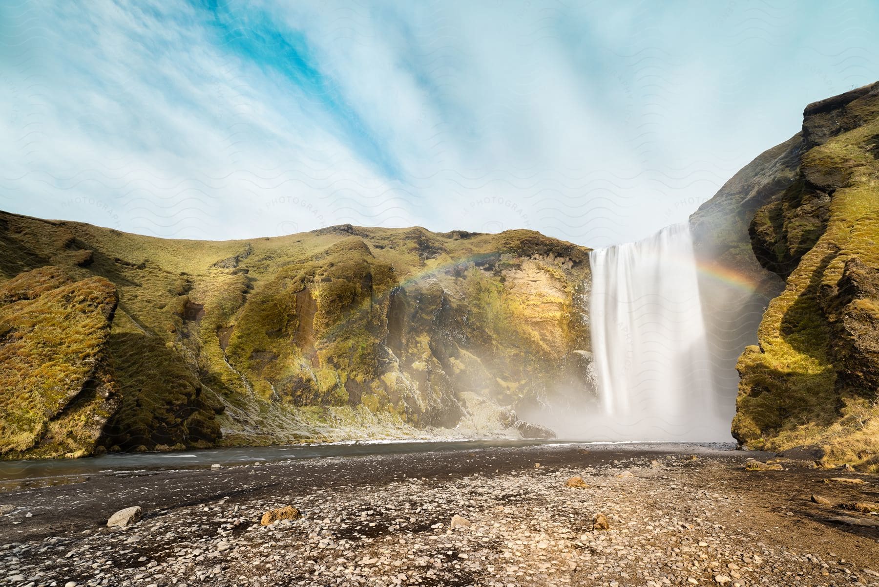 Scenic rainbow emerging from a waterfall in iceland