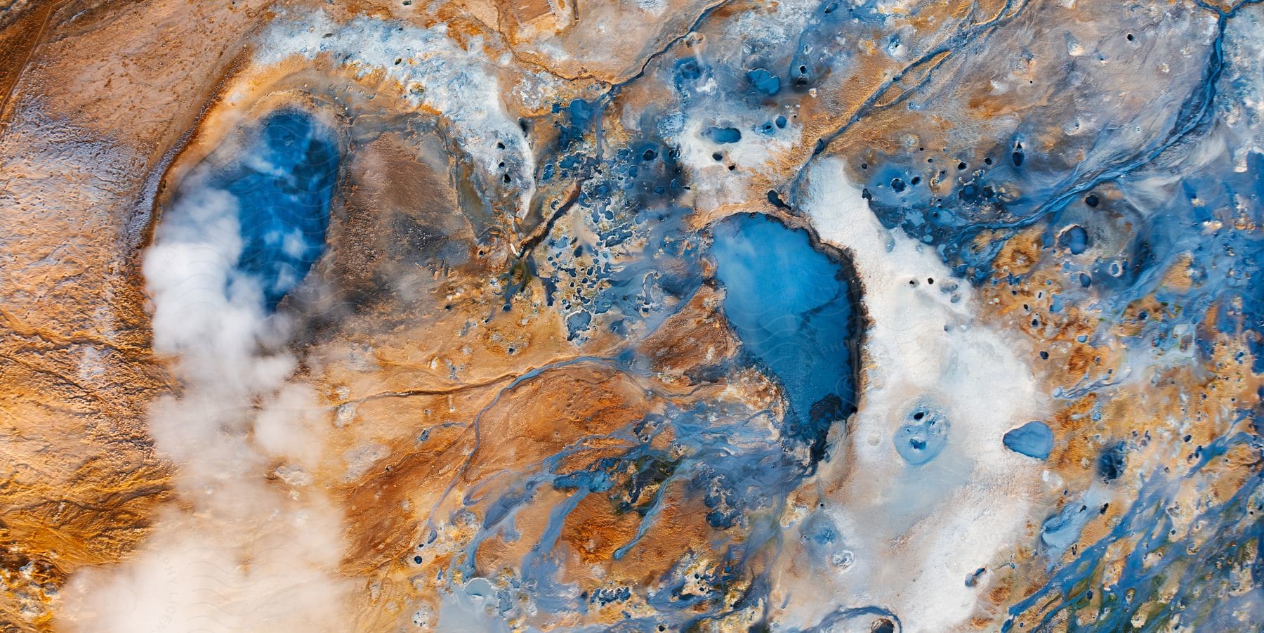 Overhead shot of sulphur pools in desert rock in iceland