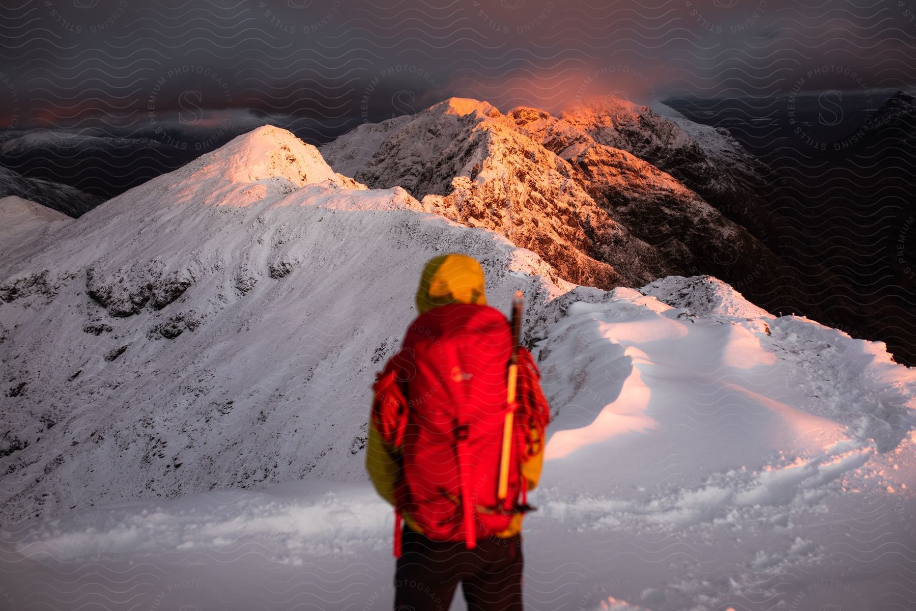 A man standing on a snowy mountain with a backpack