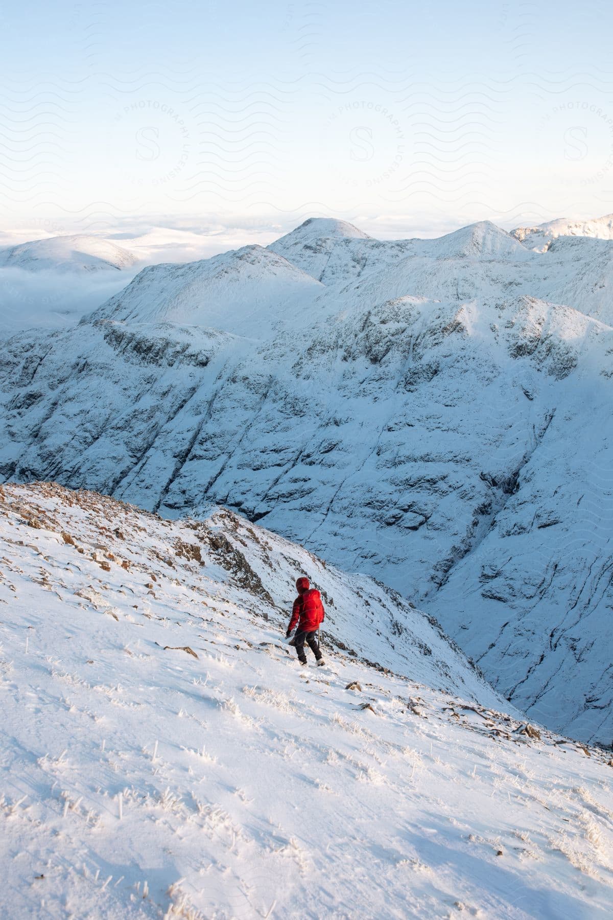 A person walking near the top of a snowy mountain