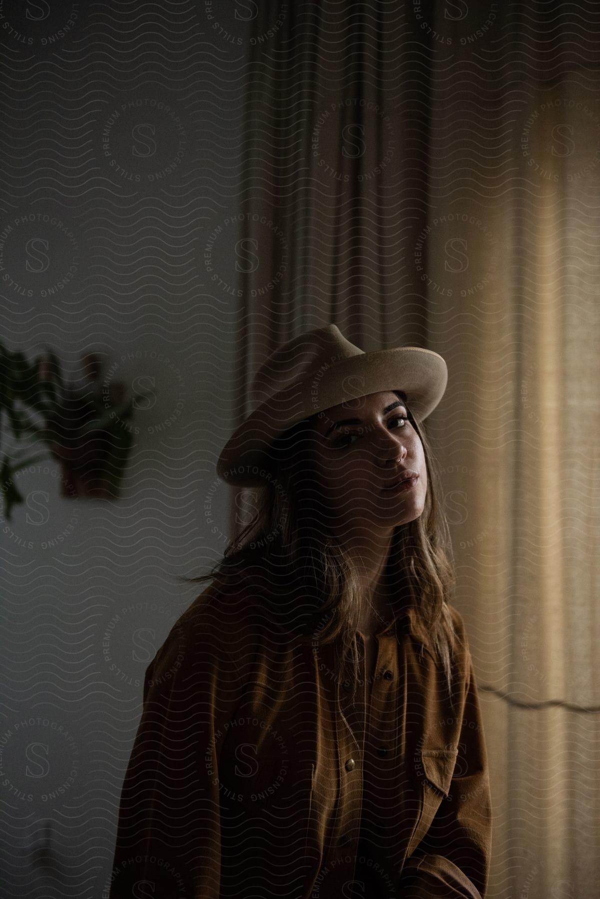 A woman sitting indoors wearing a hat