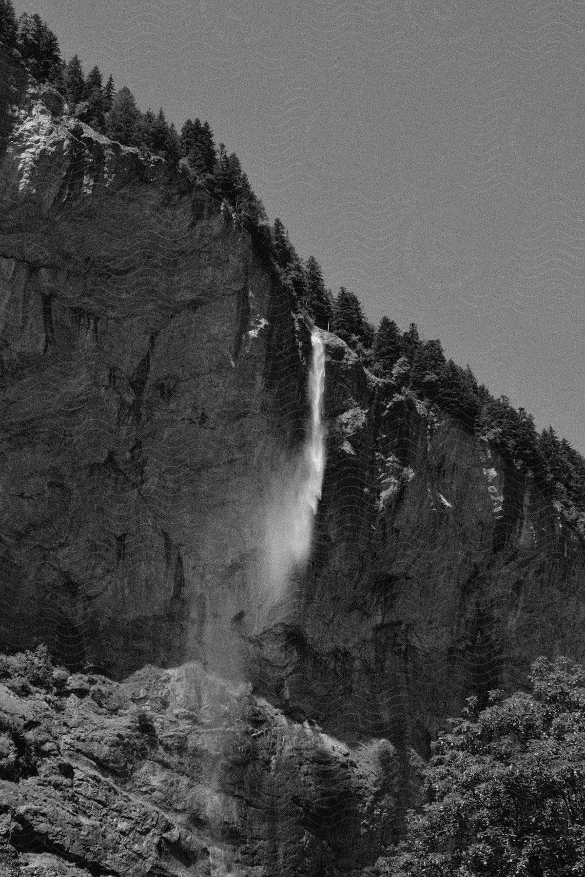 A waterfall cascades down a mountain in the switzerland alps