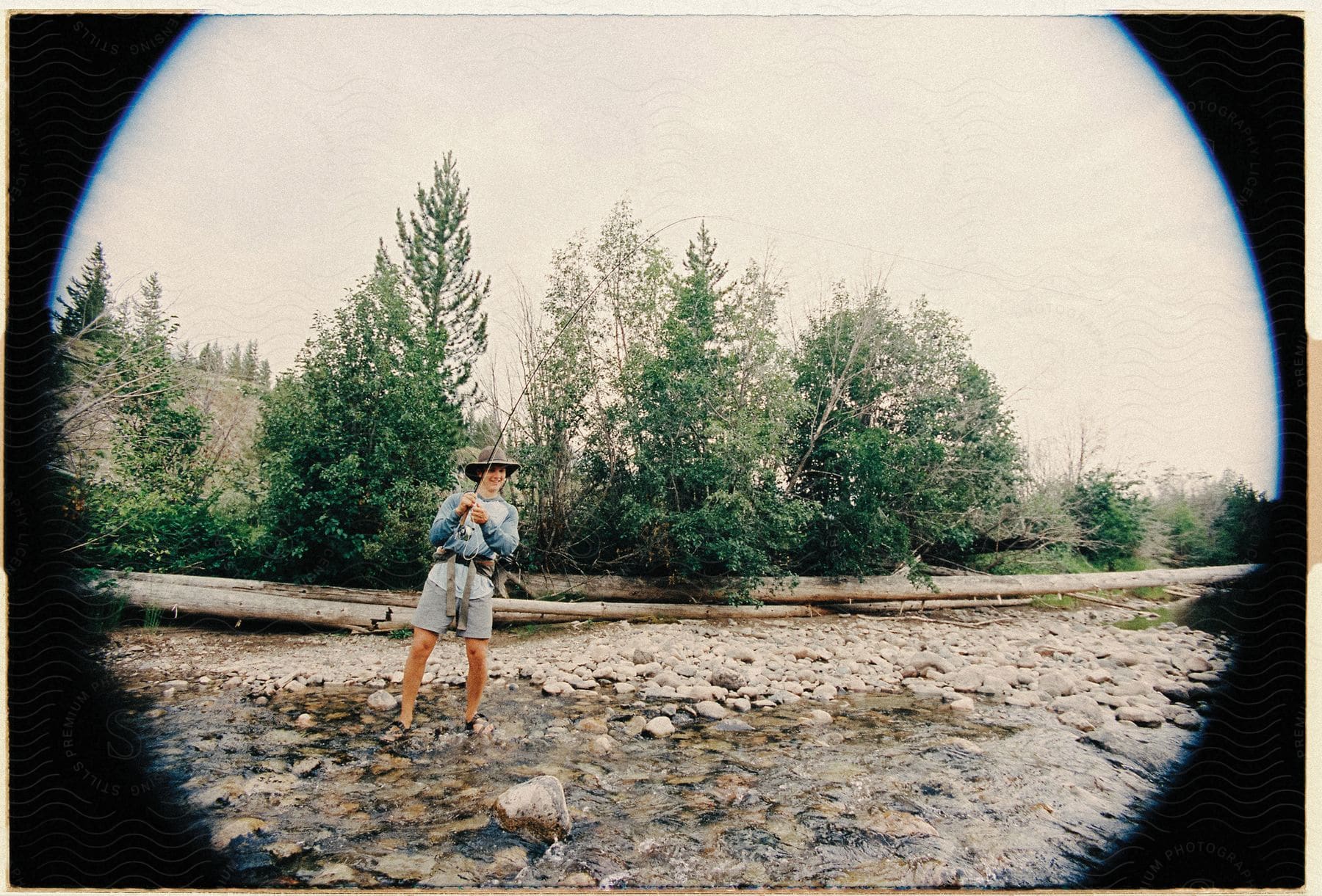 Young boy fishing in a landscape with lake and trees