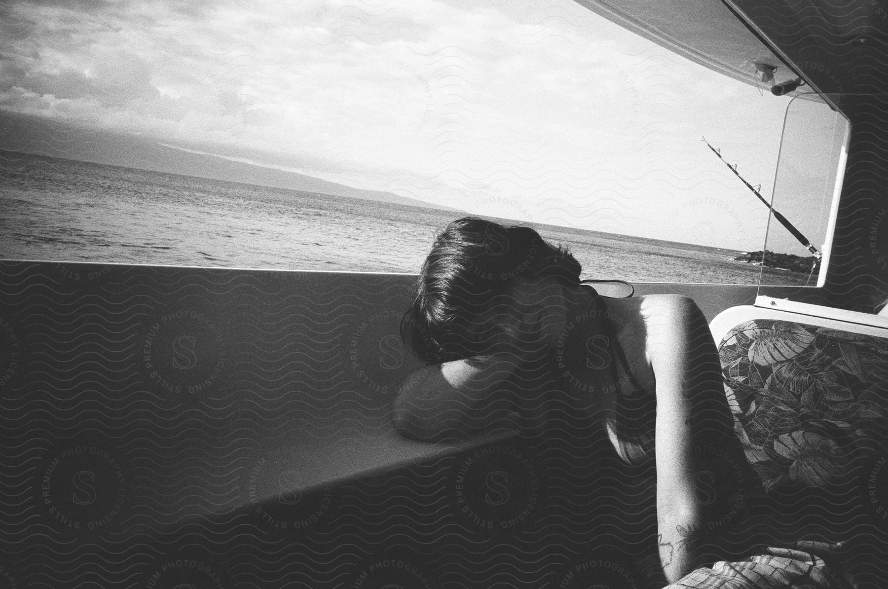 A woman rests her head on her hand while sitting in a boat