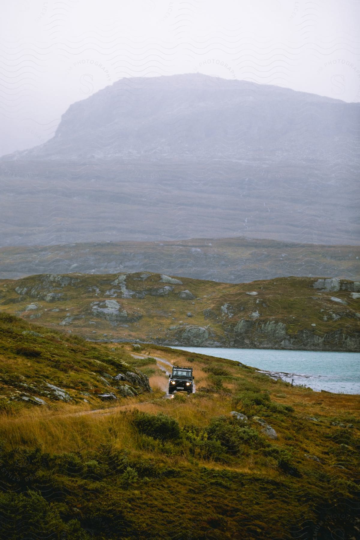 A vehicle travels on a road near the mountains