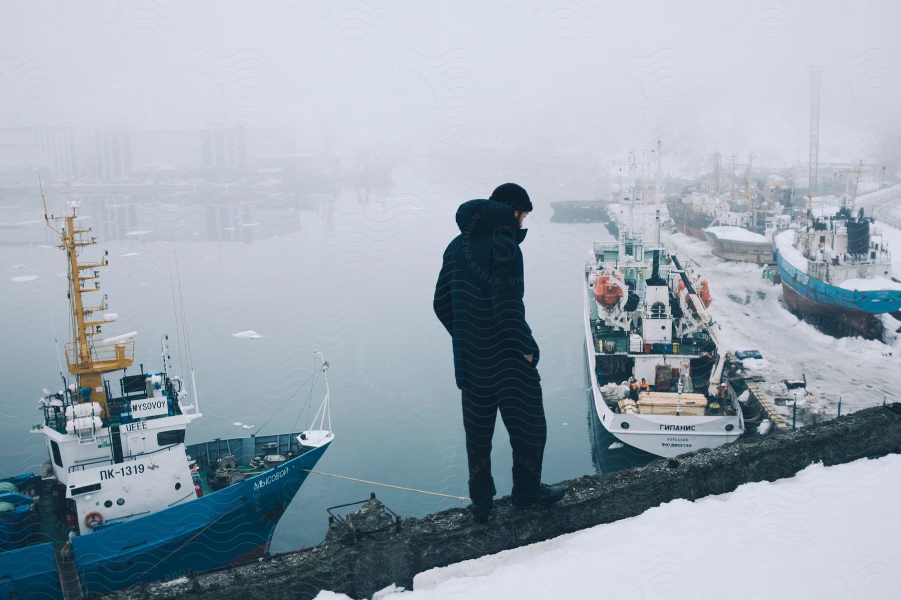 A sailor observes icy harbor waters during winter
