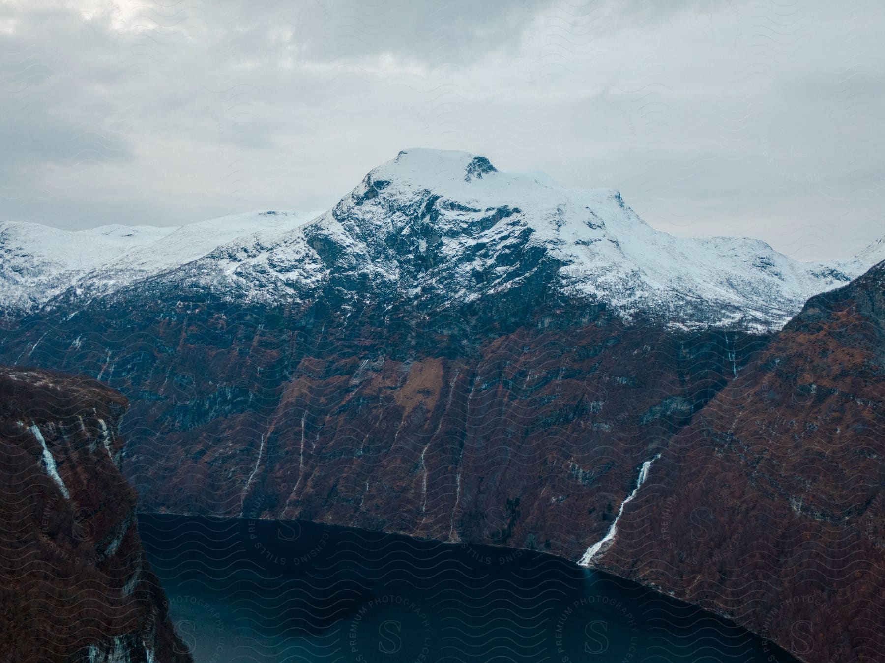 A serene winter landscape with a mountain lake and snowy trees