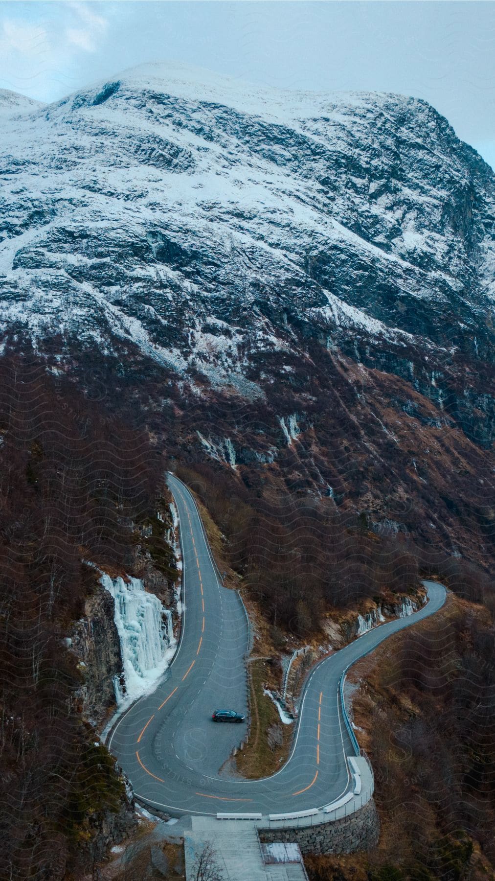 A van is parked on a mountain road near a hairpin turn