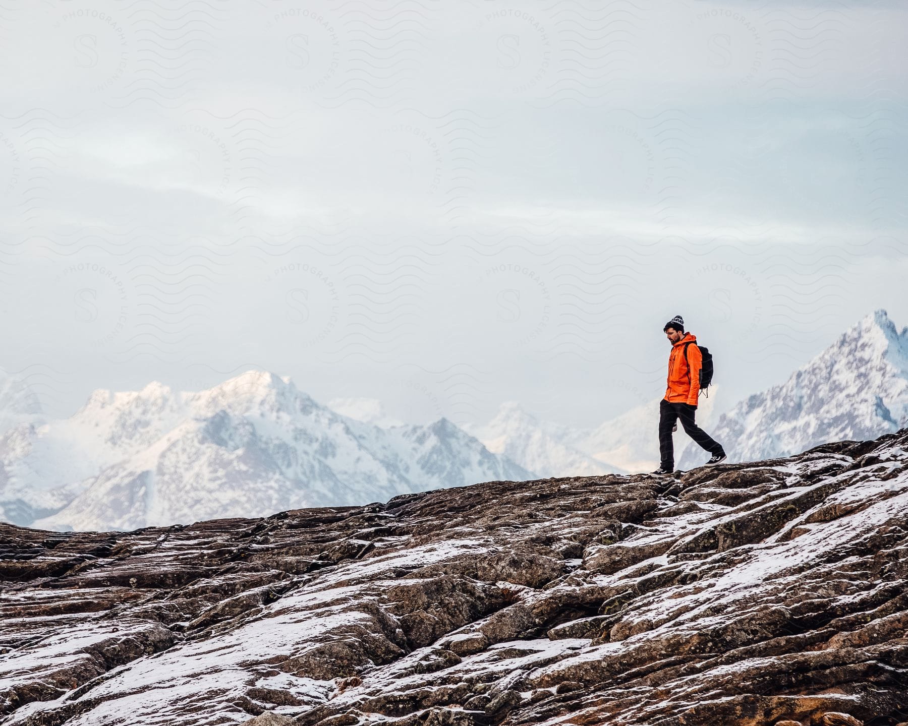 A Man Hikes Along A Snowy Mountain