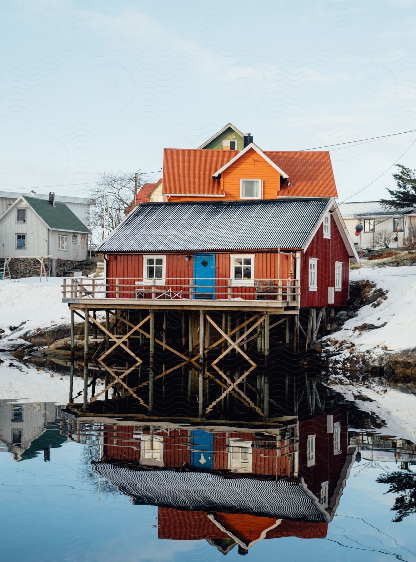 Colorful stilt house reflecting off the lake in winter located in norway