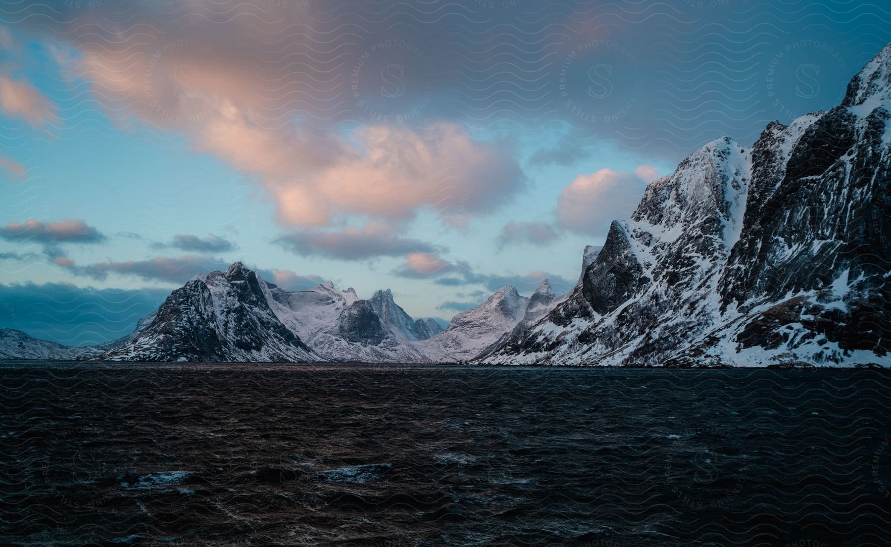 Open sea with snowy mountains on the horizon in norway