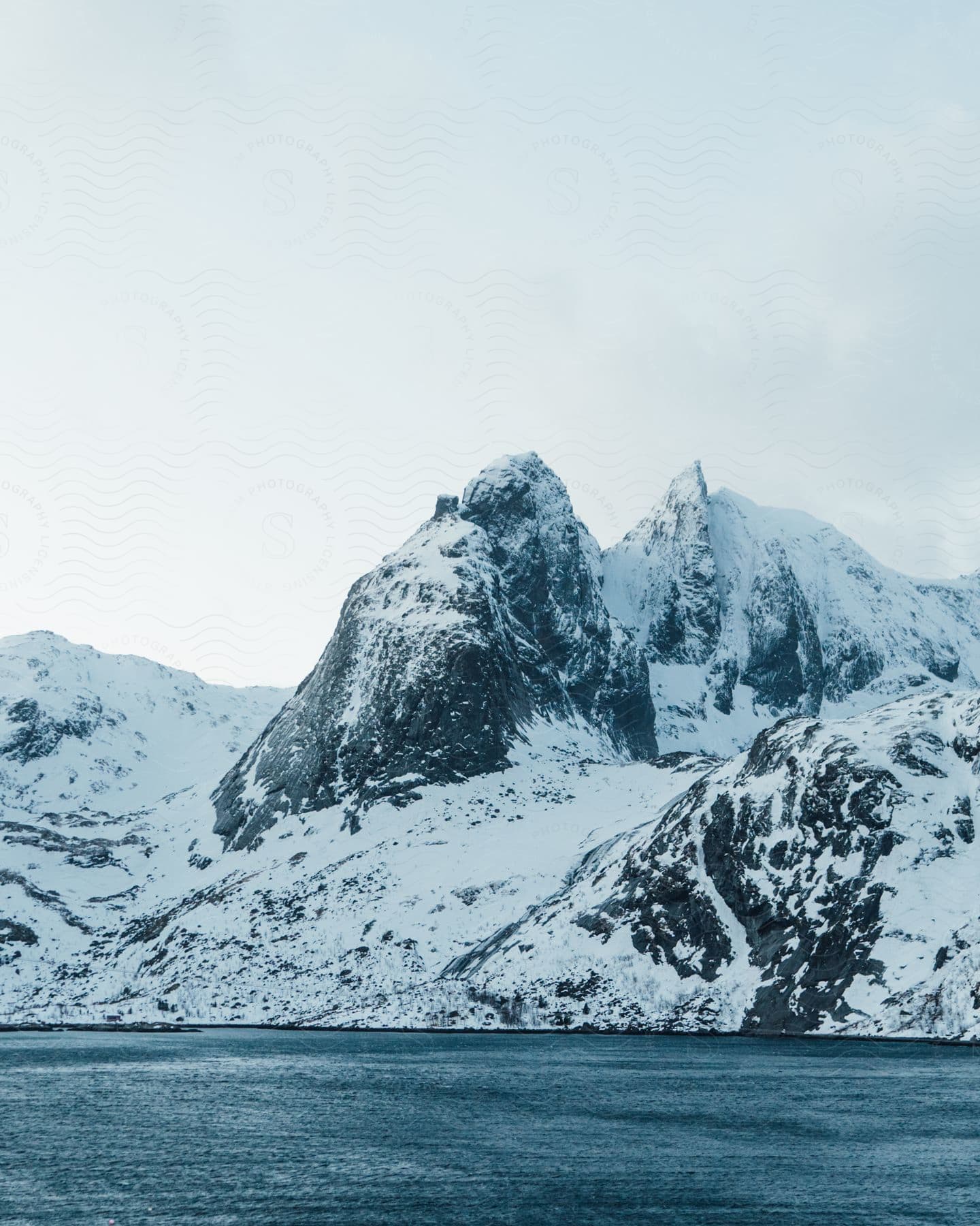 A Snowy Urban Landscape With A Mountain Range In The Background And A Frozen Watercourse