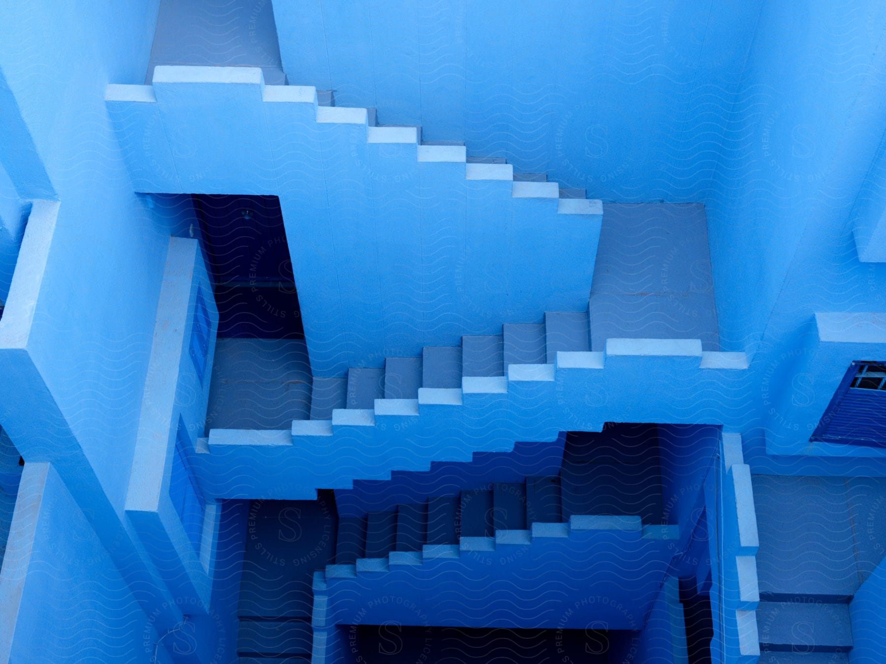 A bluepainted stairwell spanning multiple floors of a building