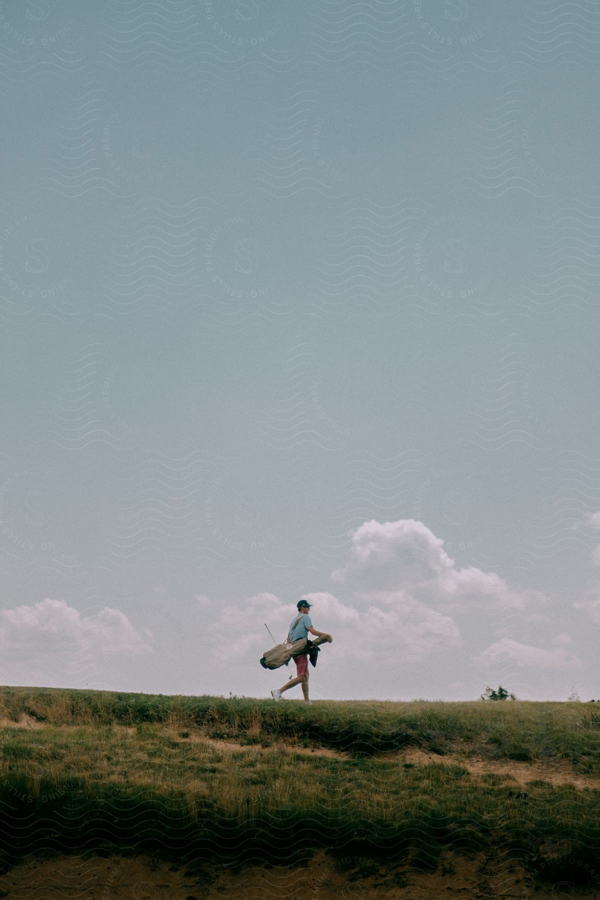 A man with a bag walking in a meadow