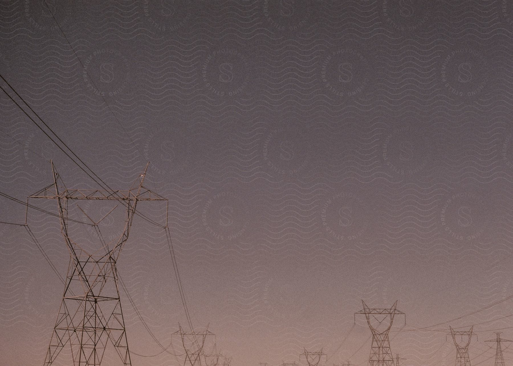 Several electrical towers against a sky backdrop