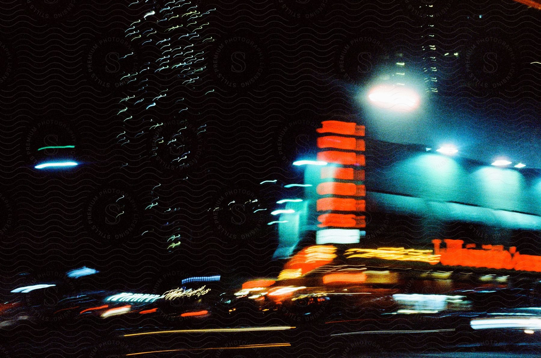 A blurred cityscape at night with bright lights illuminating an office building