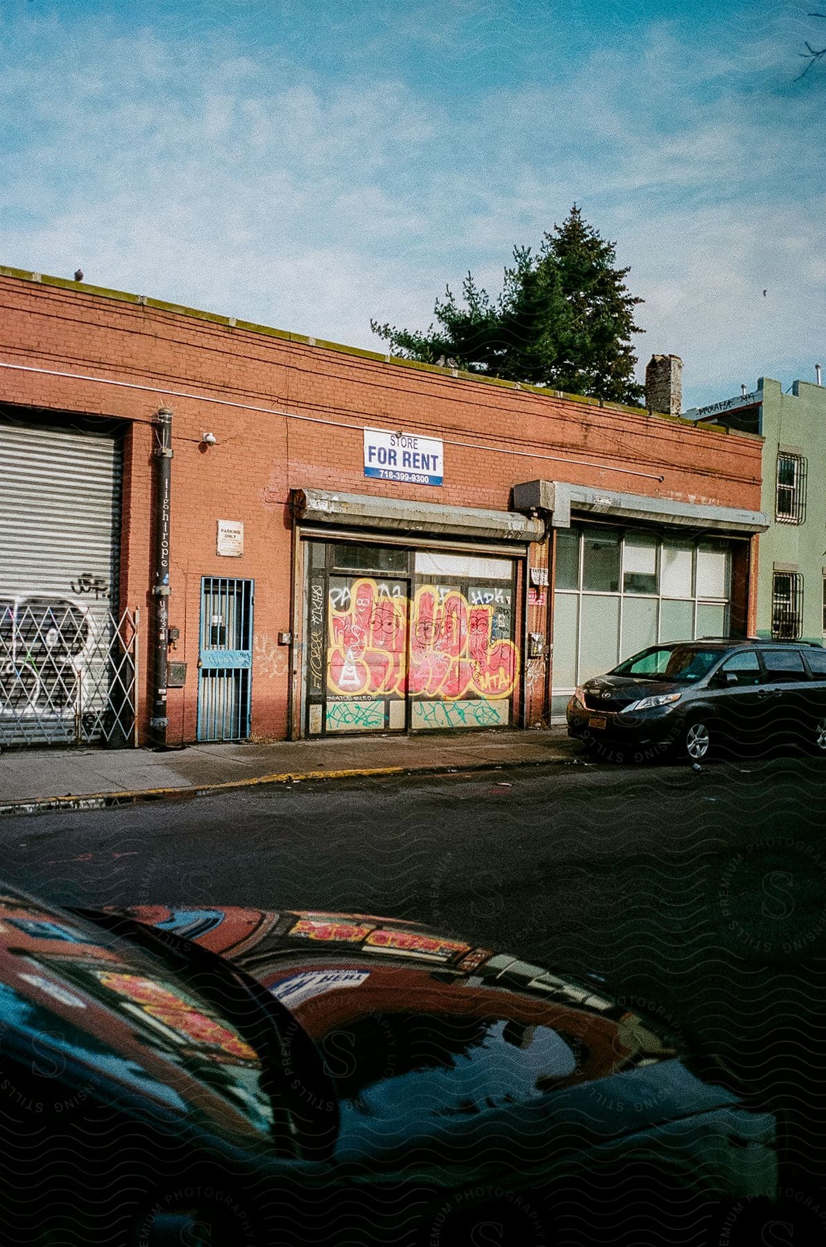 A van parked in front of a graffitied building on a small town downtown street