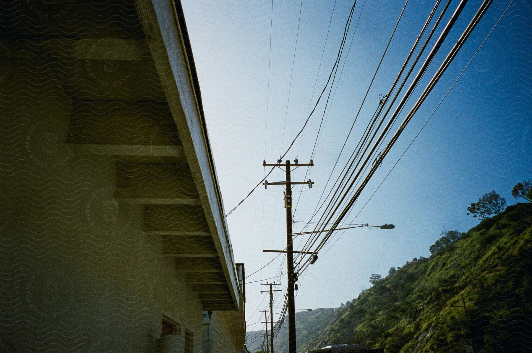 Roof light poles and green hills in view from below