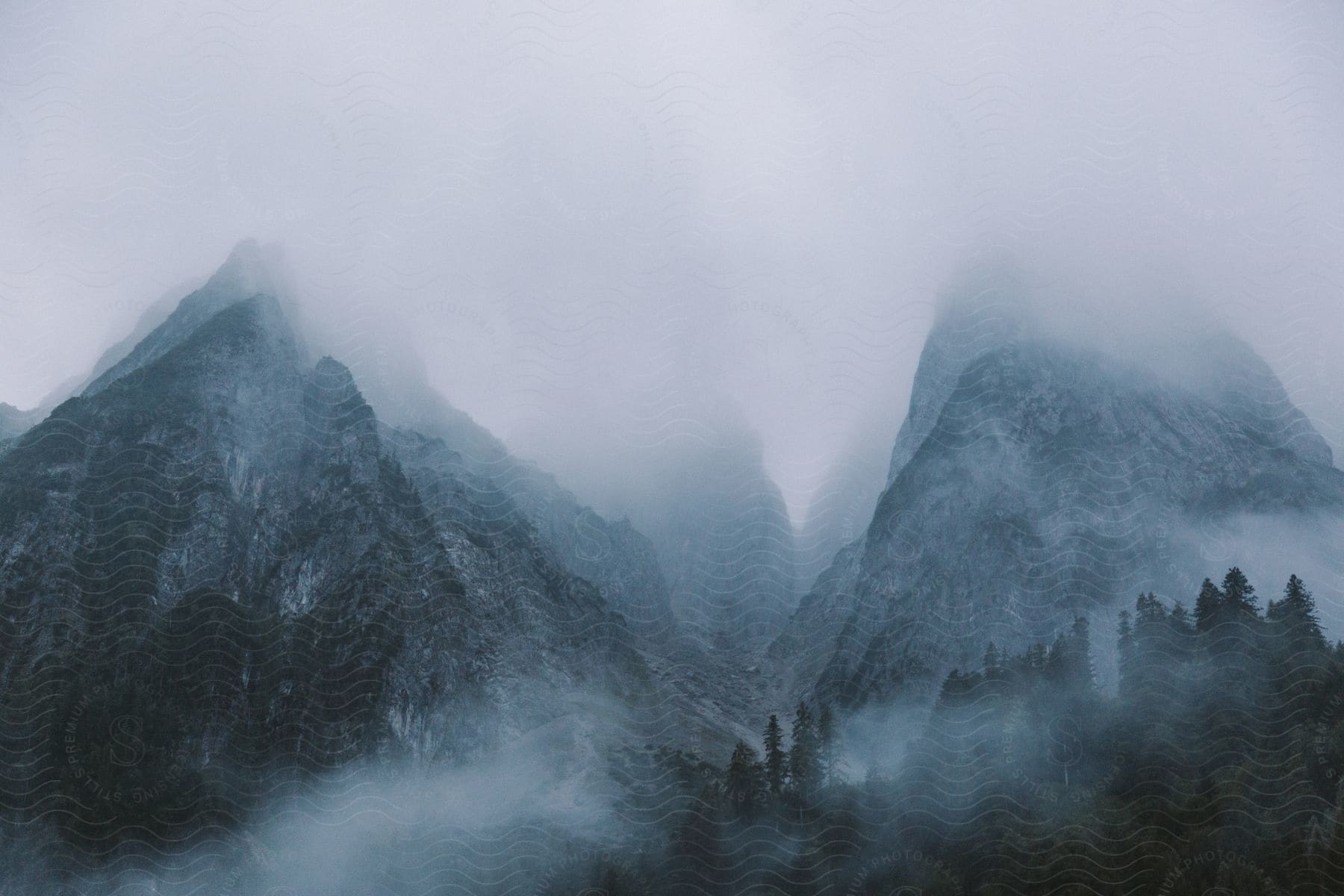 Mountain range covered in fog and mist with a cloudy sky