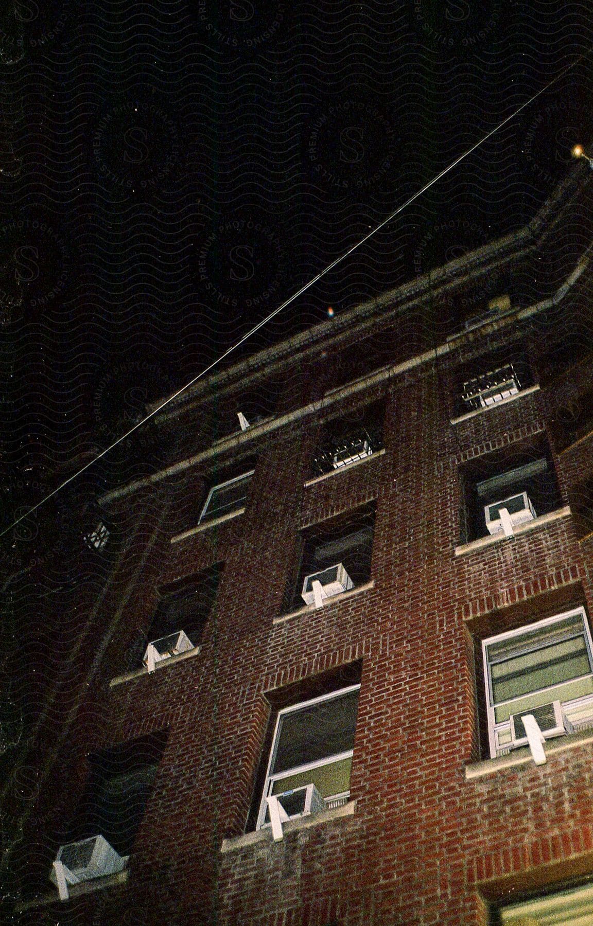 A brown brick building with many windows located in new york city at night