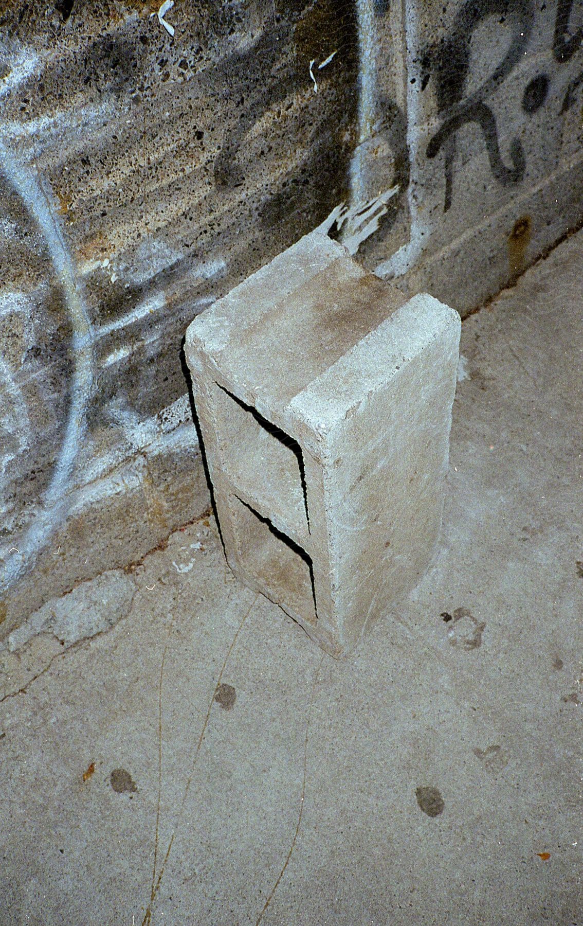 A vertical concrete brick sitting on the ground