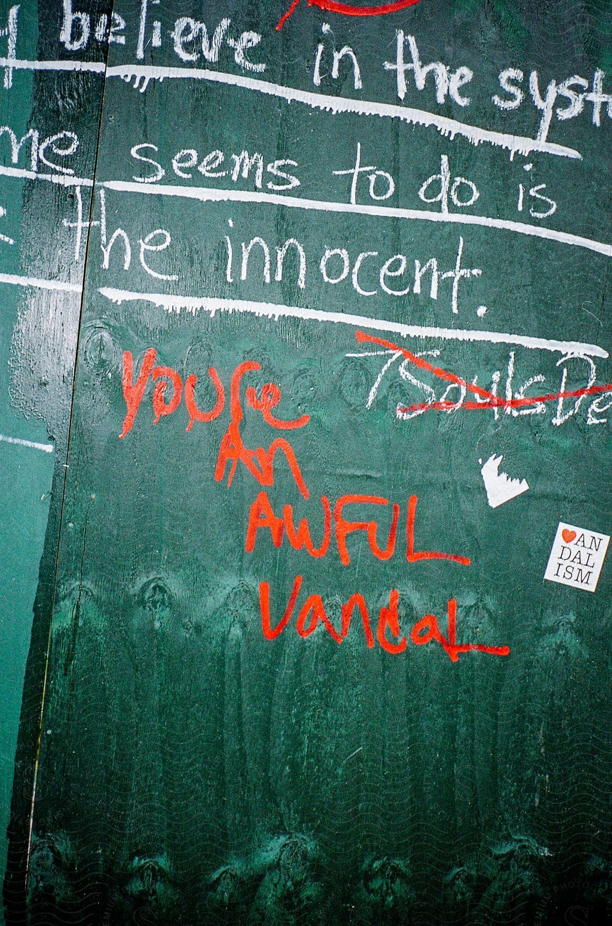 A wall with written words in white and red ink