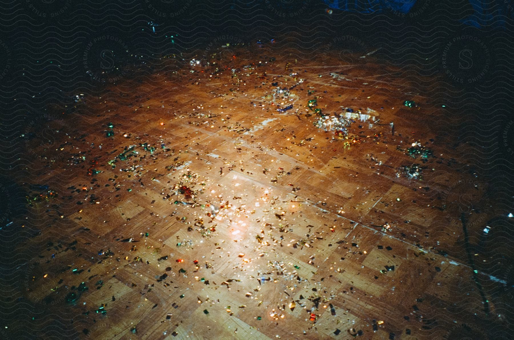 Popped confetti scattered over a wood parquet floor