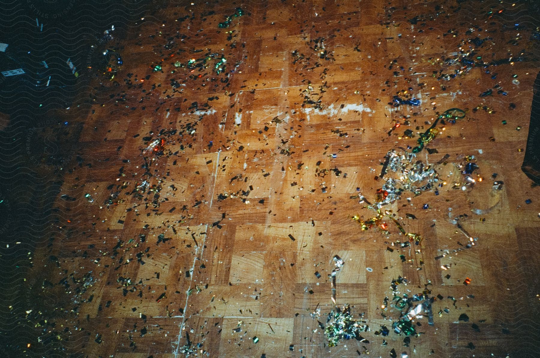 Brown cross hatched patterned linoleum floor with confetti scattered on it