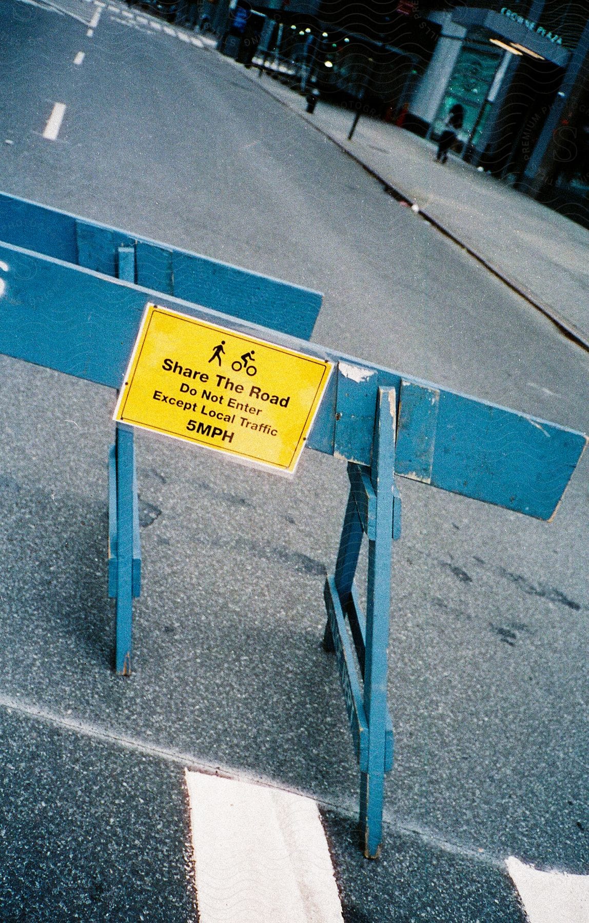 A city street blocked by a sign on a sawhorse