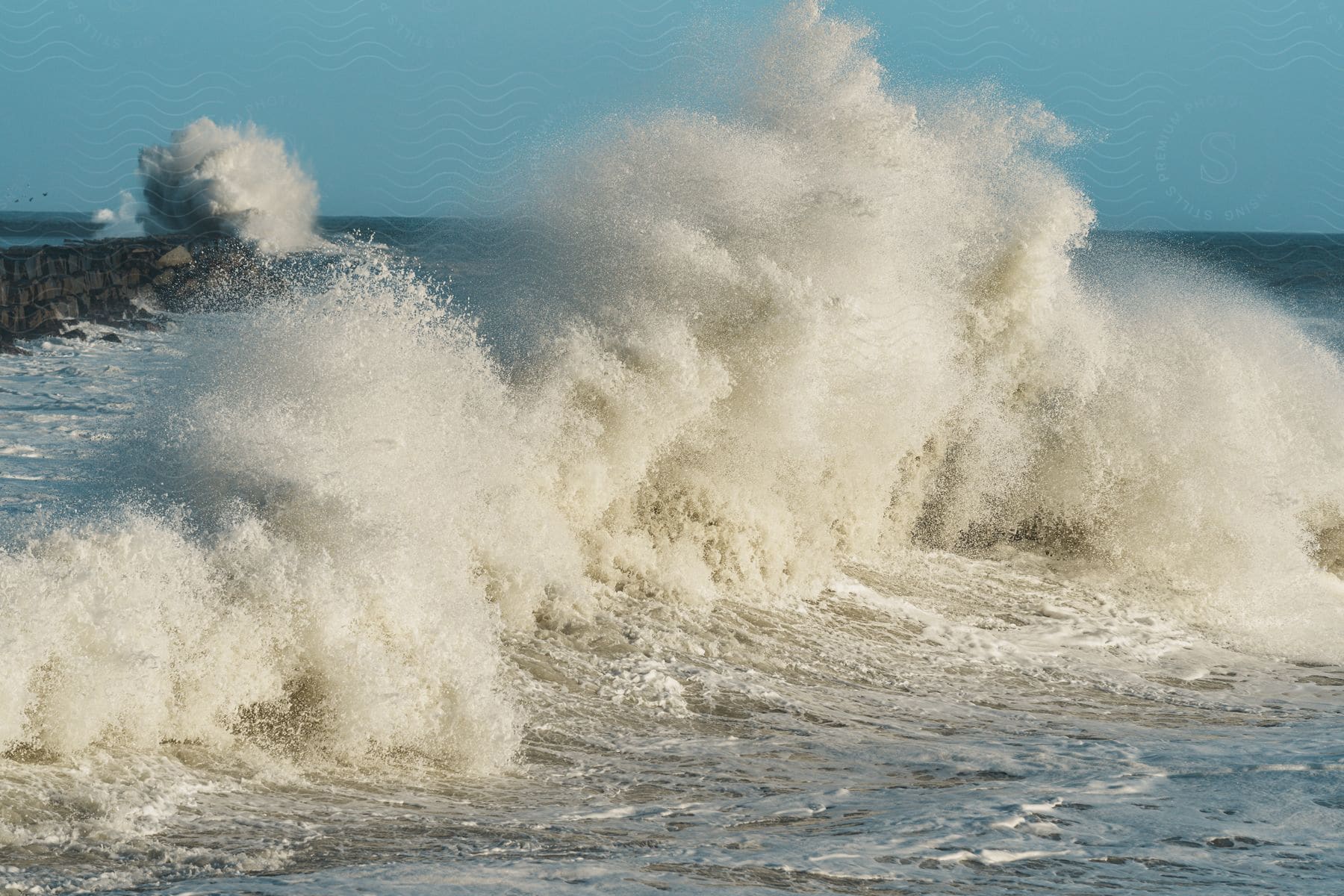 Large waves crashing on a stone pier in san pedro during a storm surf