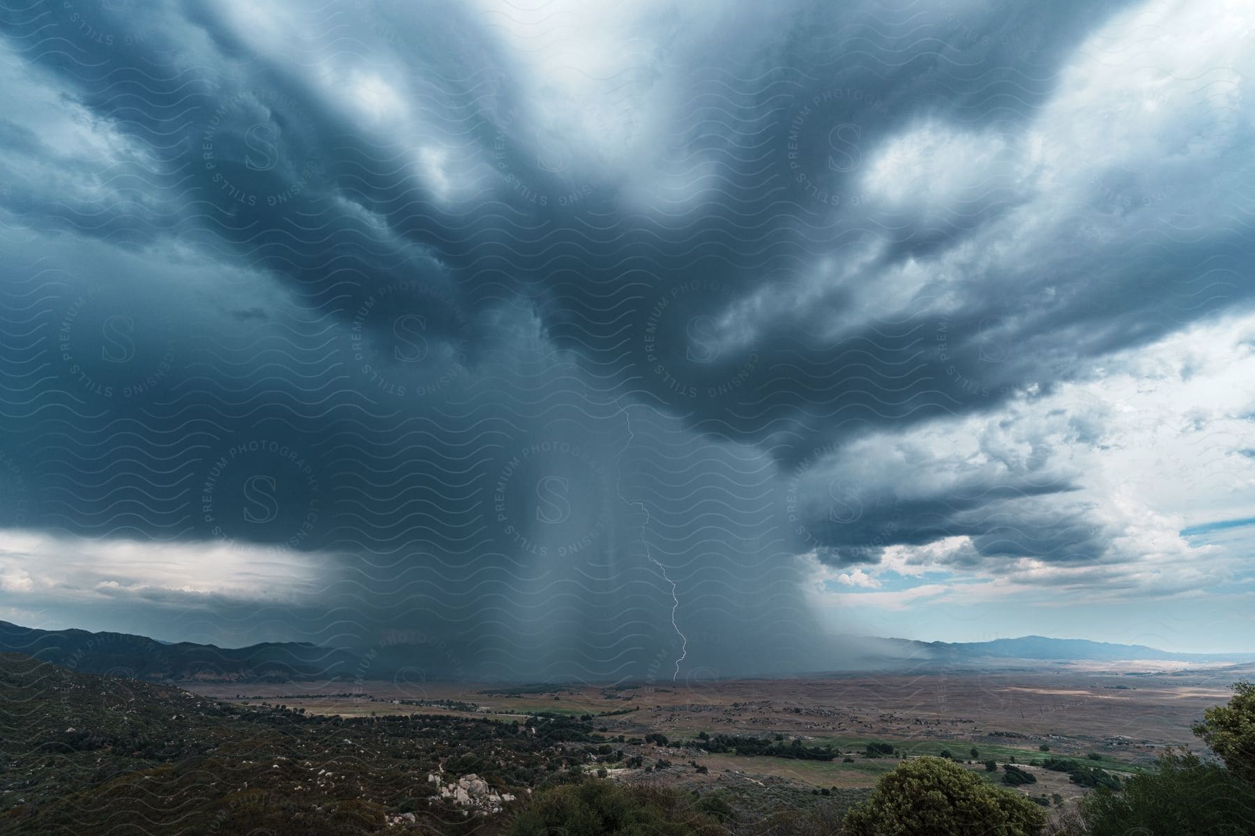 A thunderstorm with lightning and heavy rain over the plains during the day