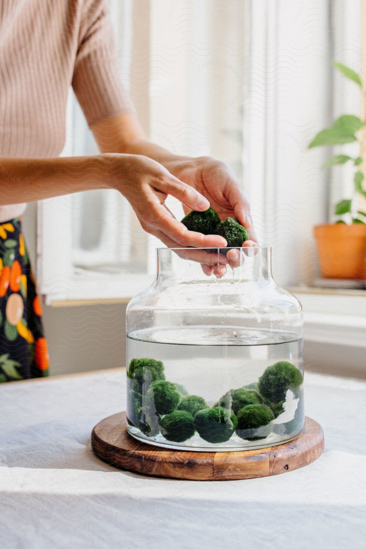 Woman placing broccoli florets in a glass jar filled with water