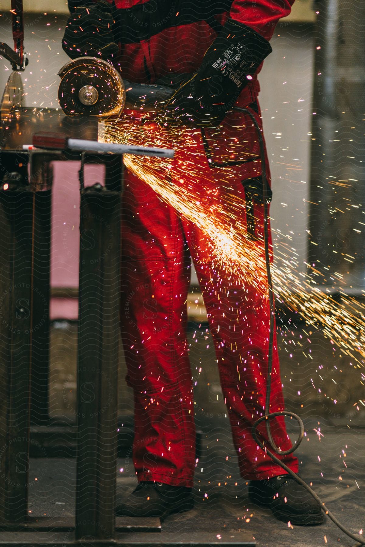 Worker grinding metal in a shop with sparks flying