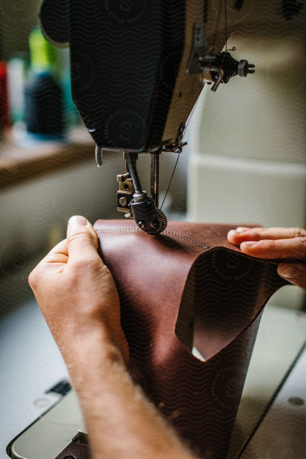 A man sewing leather on a machine