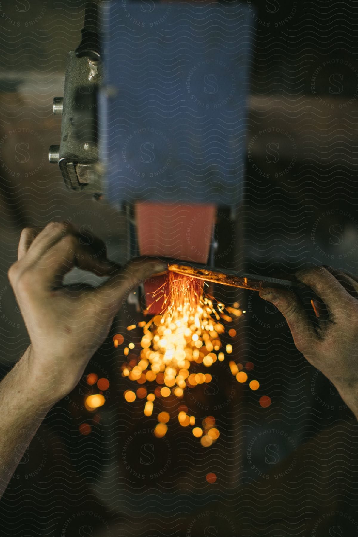 Hands Holding An Iron Tool On A Machine In An Interior Setting