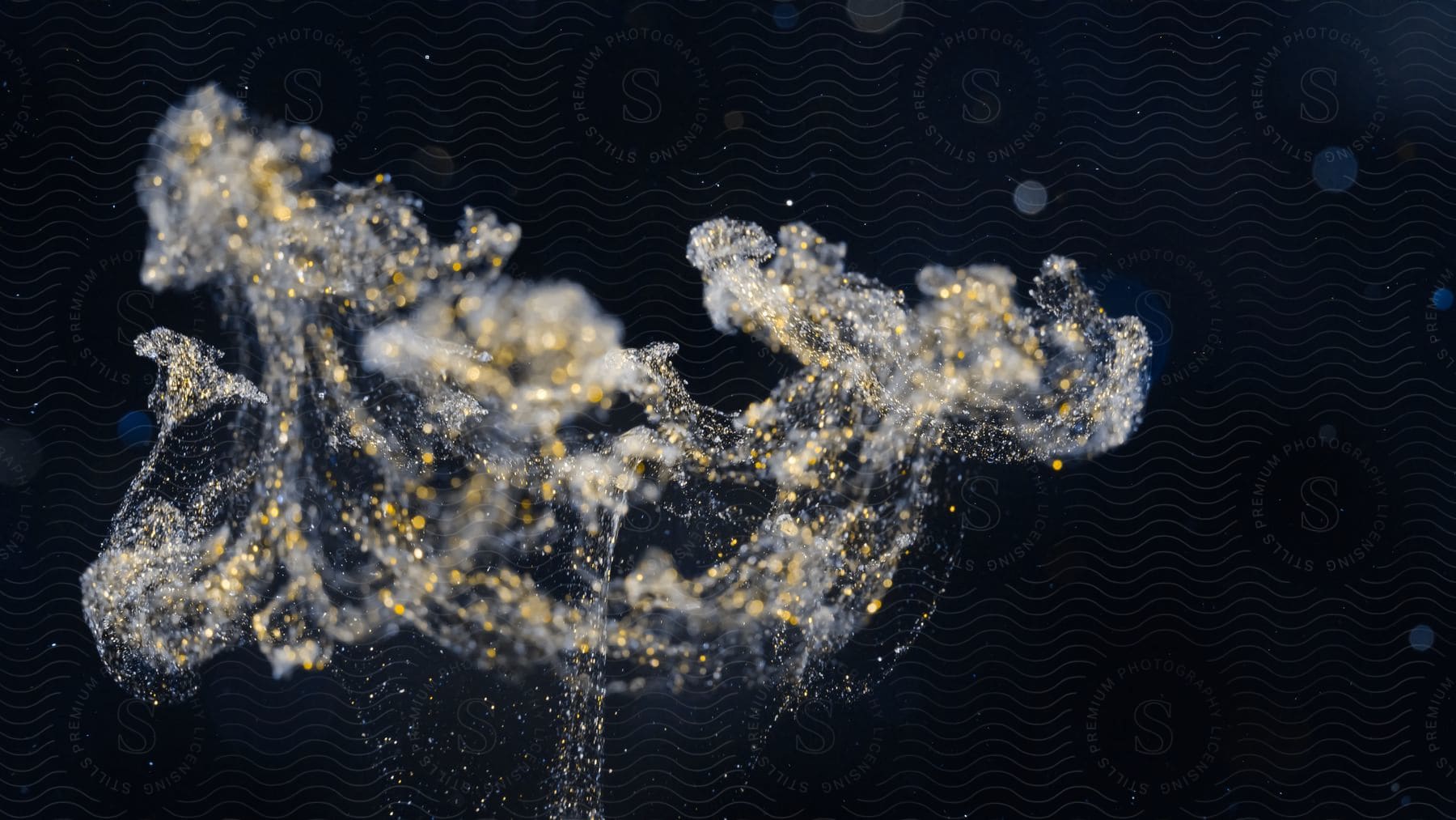 Close up of wisps of white ink with glitter floating against a black background