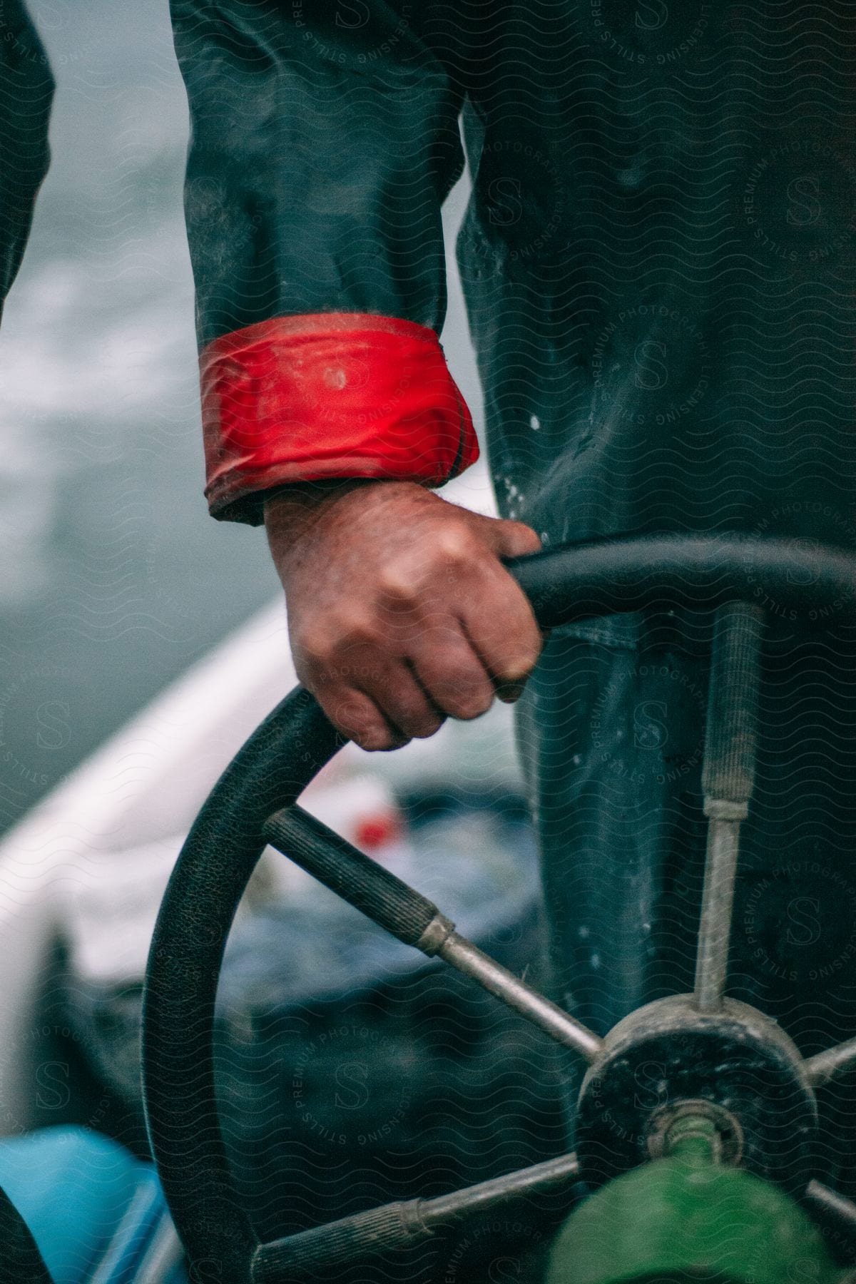 A man in a working suit rolling a steering wheel