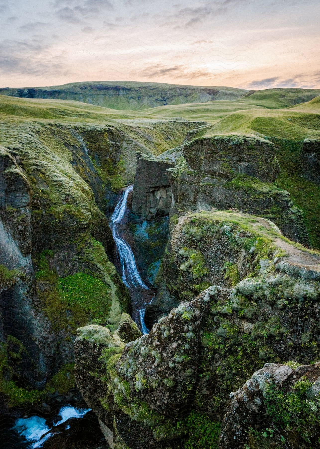 Landscape with rocky mountains vegetation and a waterfall