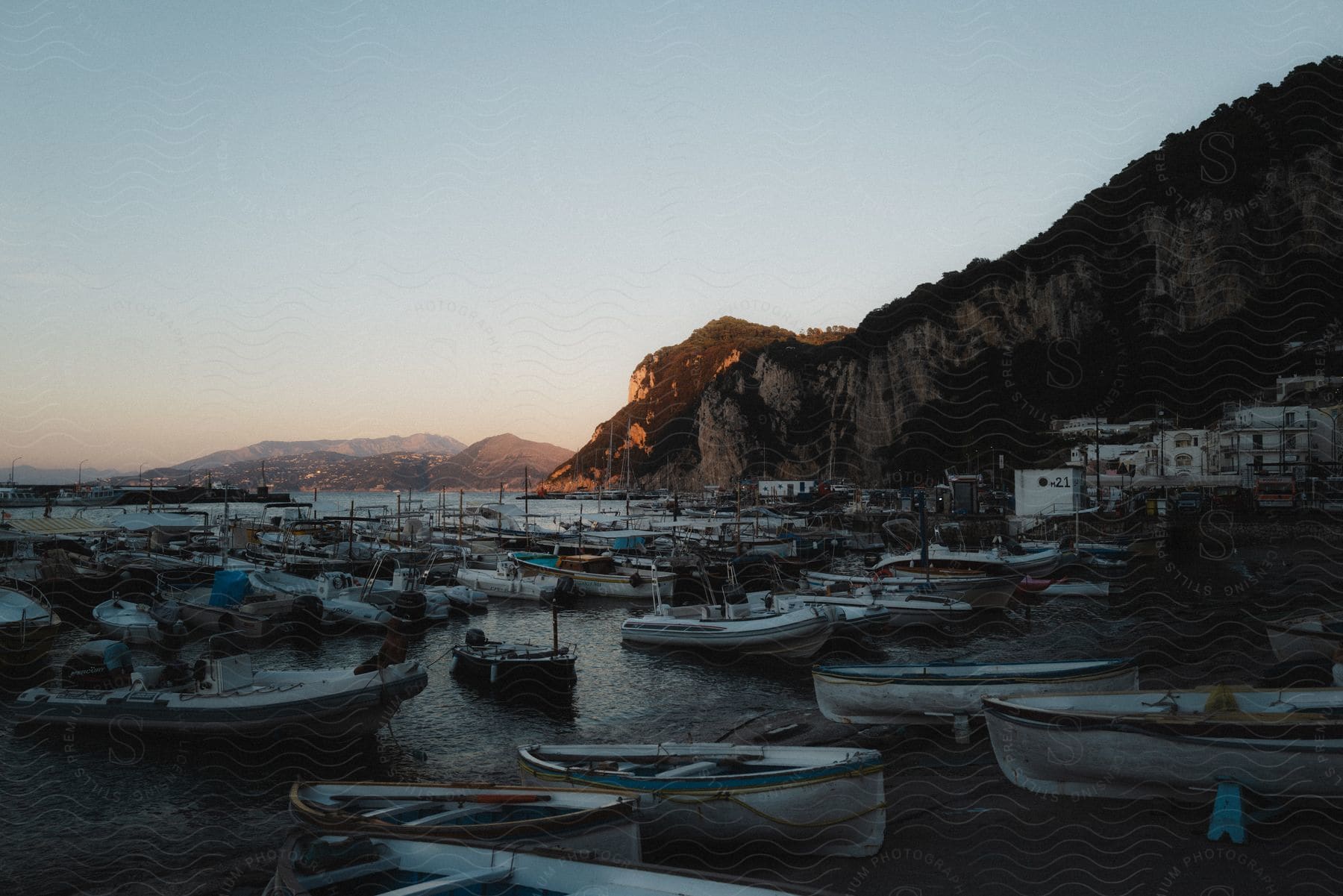 A beach with fishing boats and mountains in the background