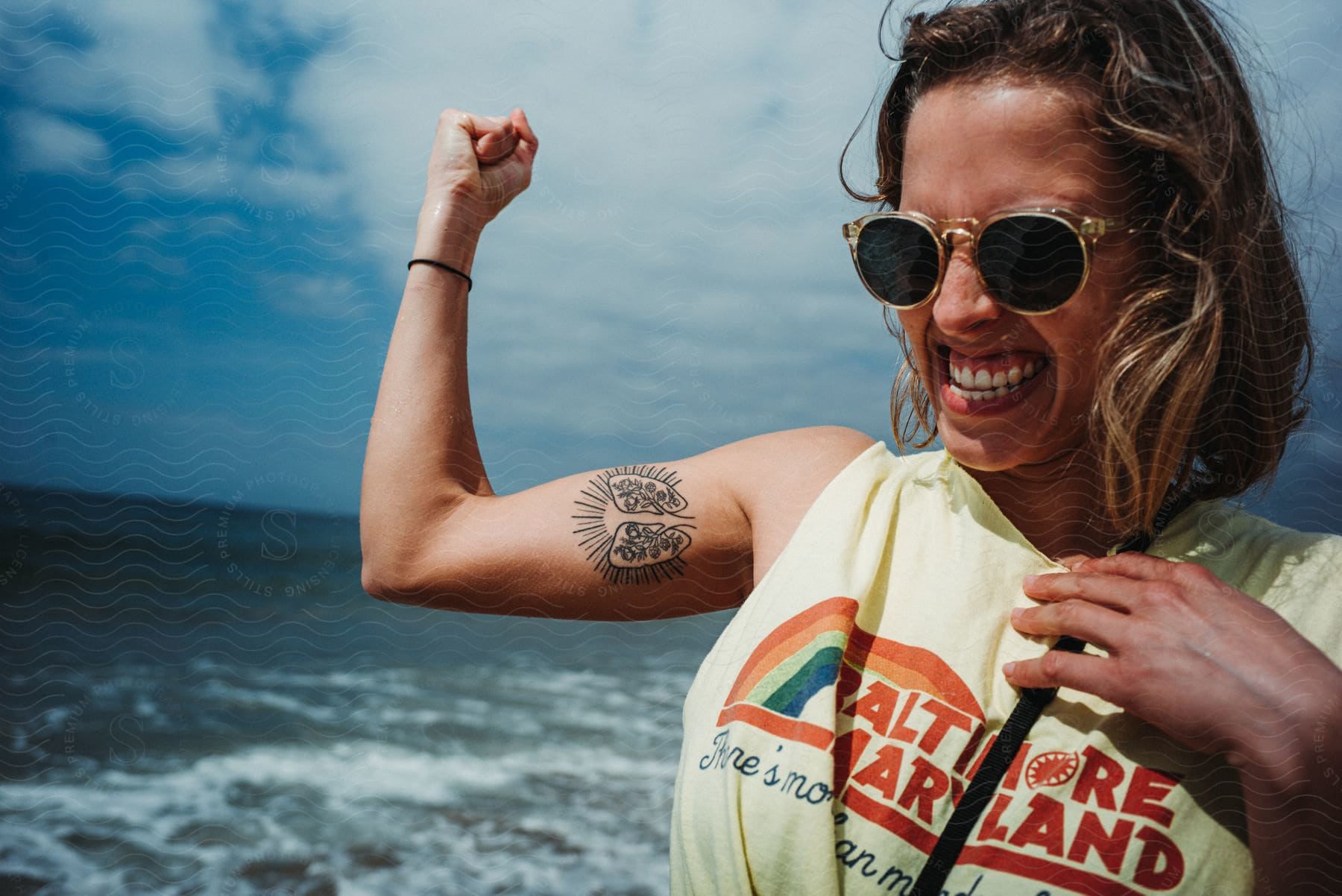 A woman laughing and flexing her muscles in open water