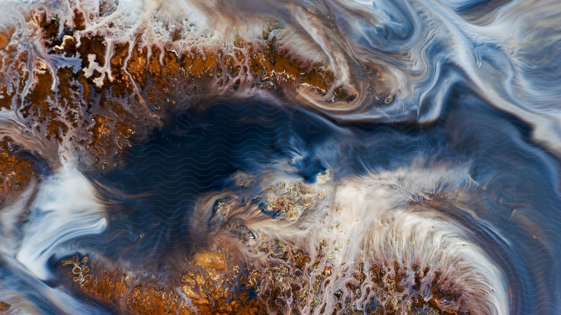 Brown and white swirls in a blue smooth fluid