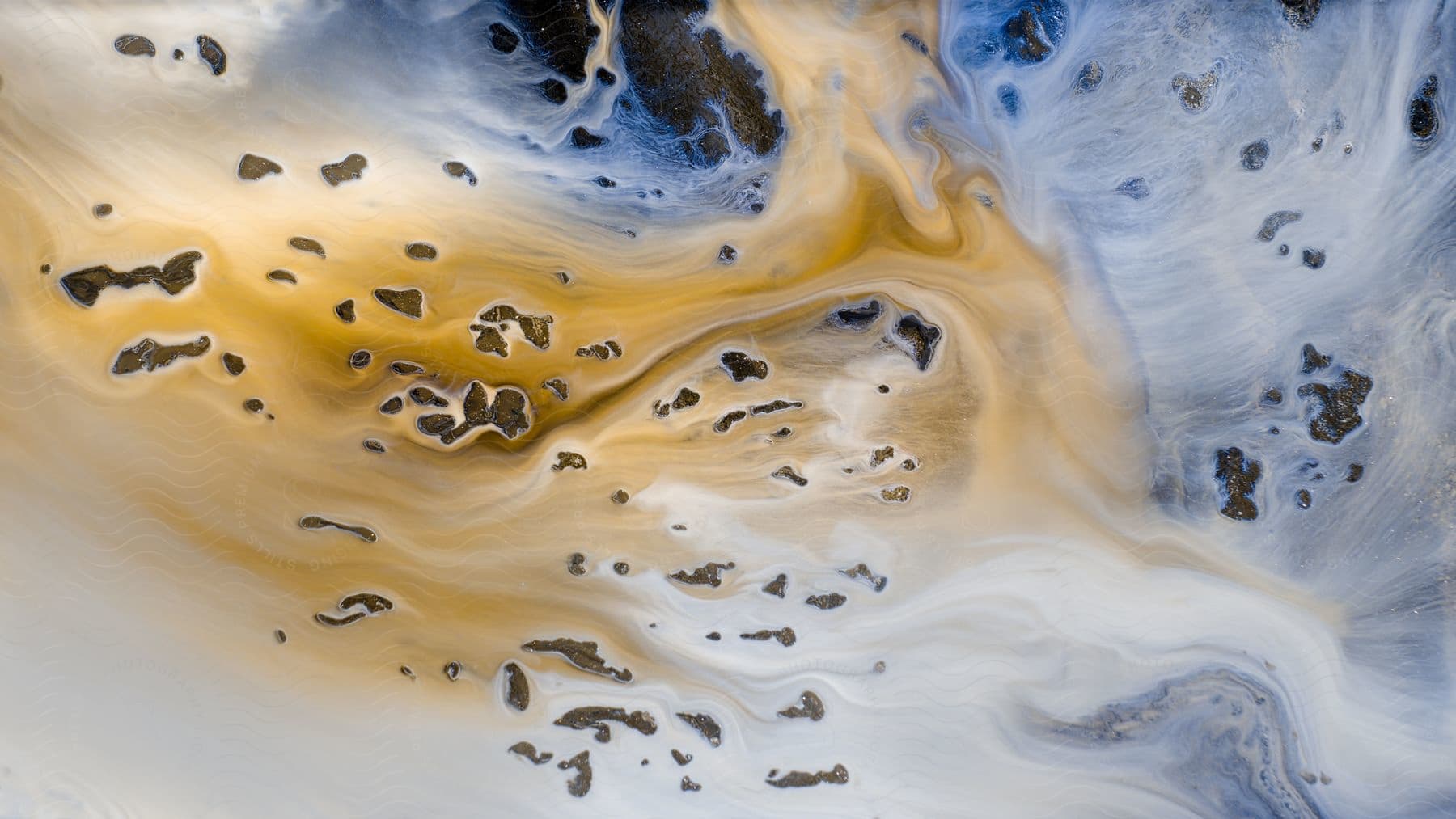 Brown and white liquid mix on a dark surface