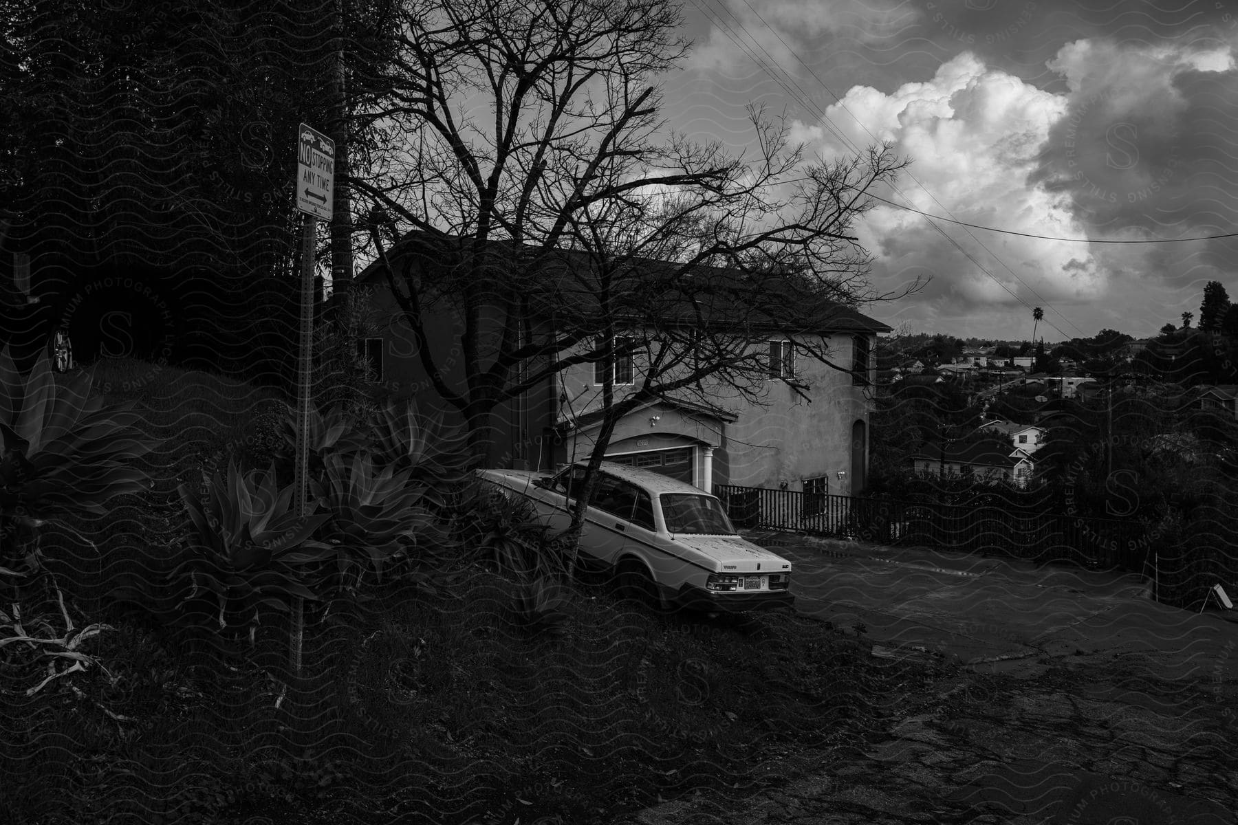 Car parked in front of a house in a suburban neighborhood with trees around