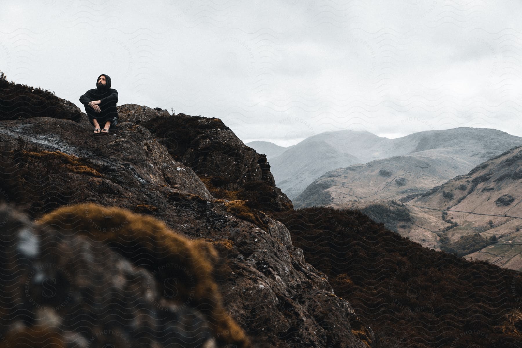 A man sitting on a hill in the mountains