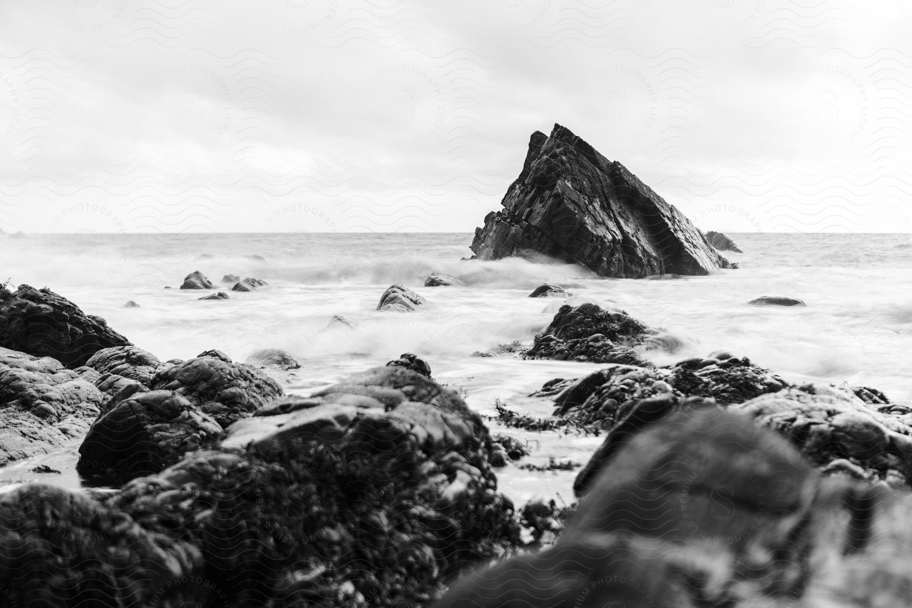 Ocean waves crashing against the shoreline on a coastal rock