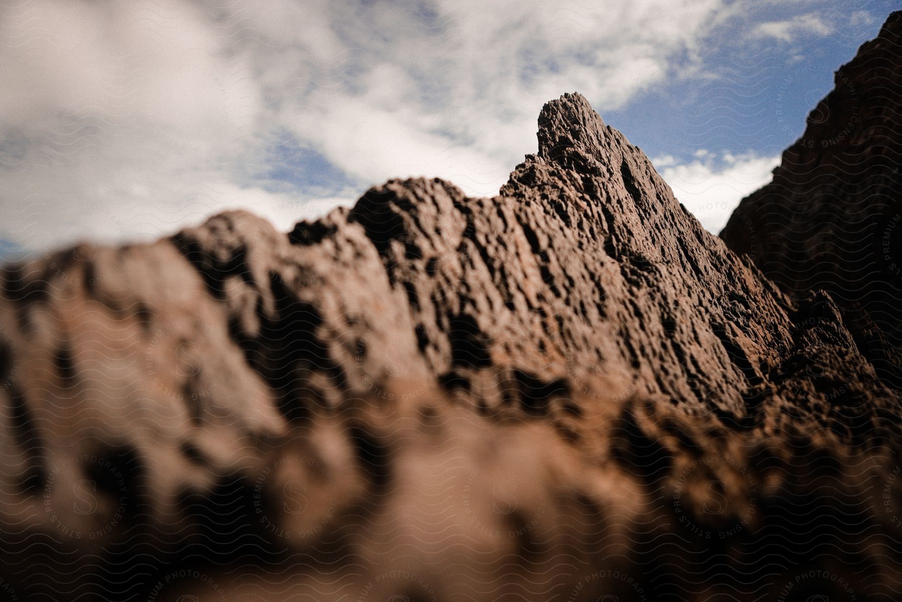 A natural landscape of a rocky cliff in the wilderness with a cloudy sky