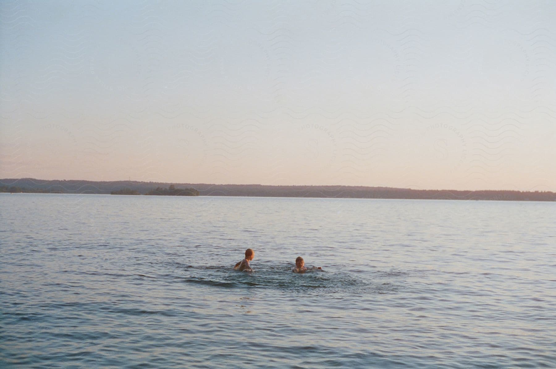 Two swimmers enjoy a hazy day at the lake