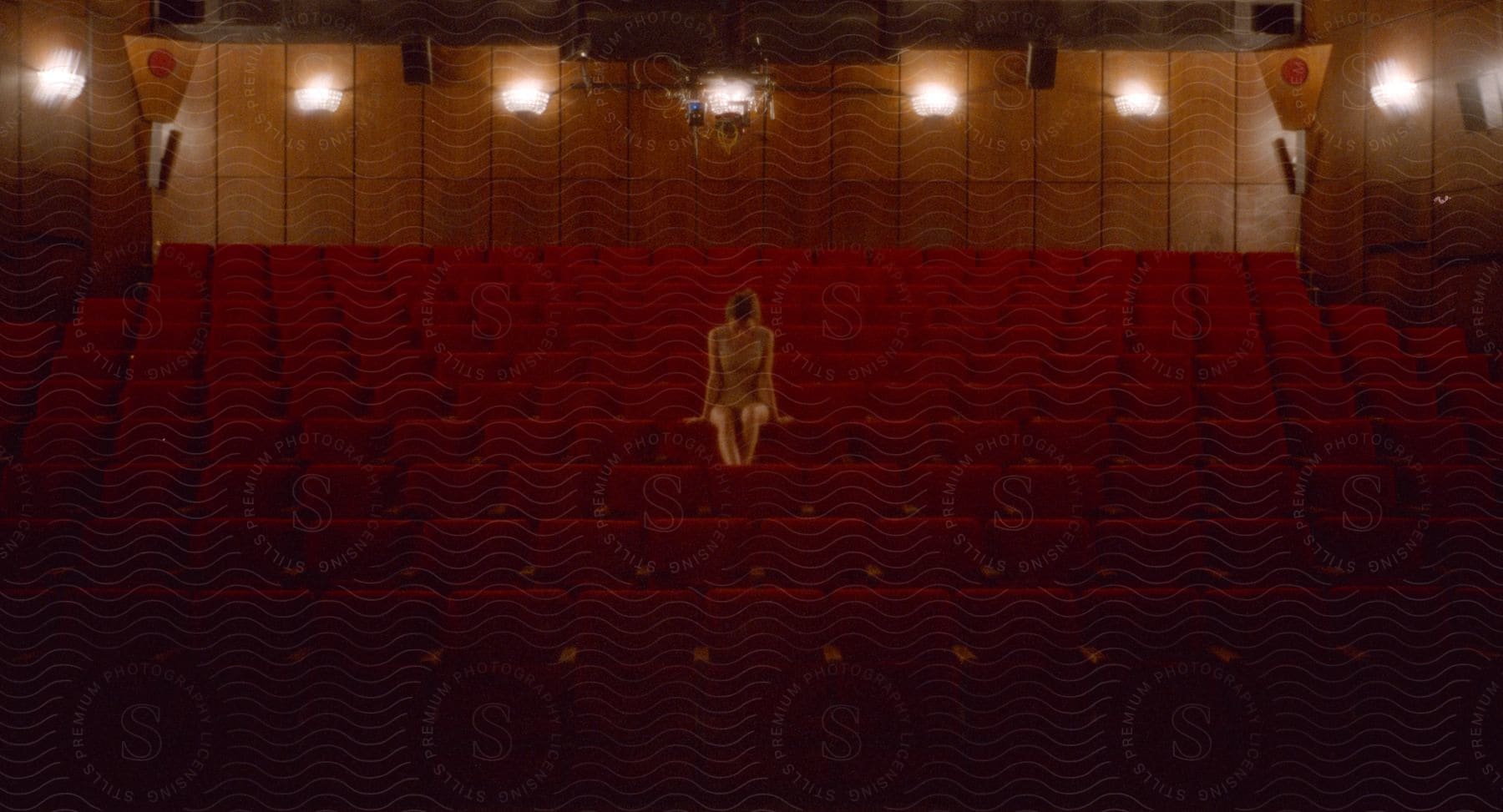 A young woman sitting on a chair in an auditorium