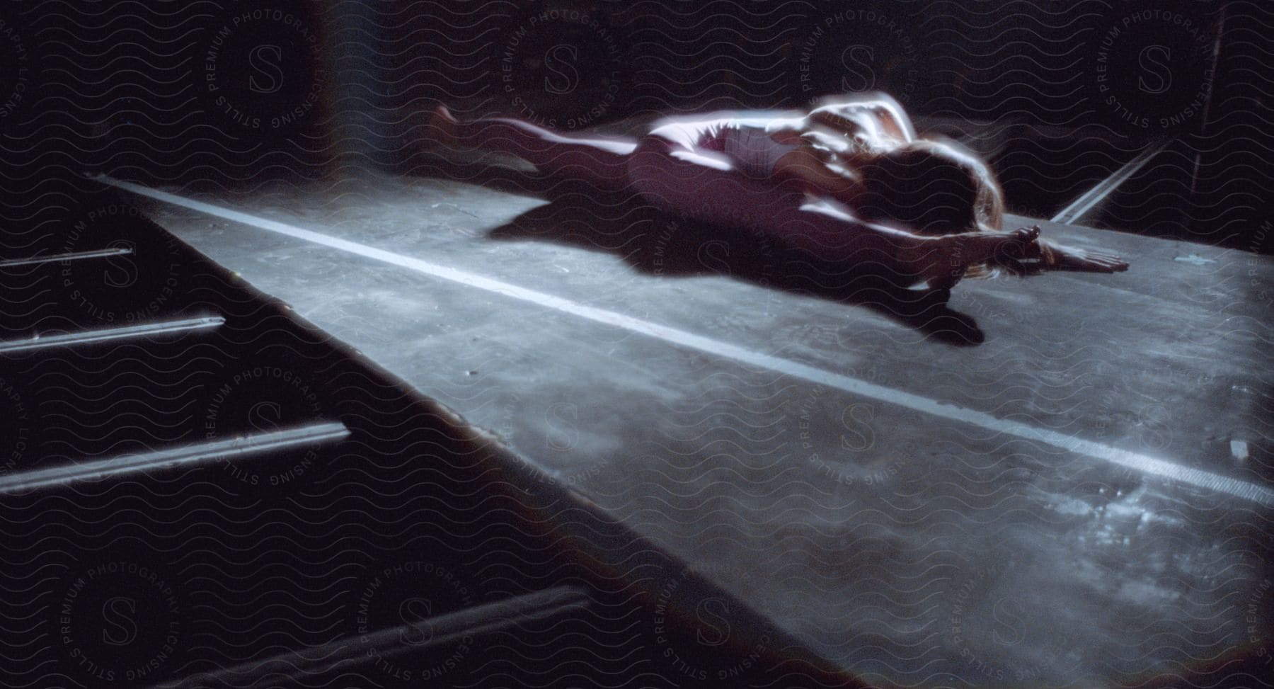 Ballet dancer stretching in a dimly lit theater